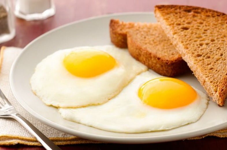 Яйца жареные с хлебом на тарелке