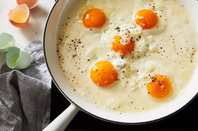 Жареные яйца в сковороде на столе